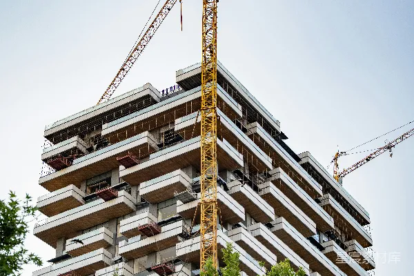 高清摄影 正在建设中的现代建筑，上面有起重机和许多阳台。