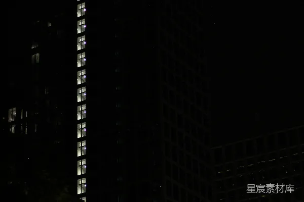 高清摄影 一座高大的建筑物在夜晚被照亮，背景是黑暗的天空。