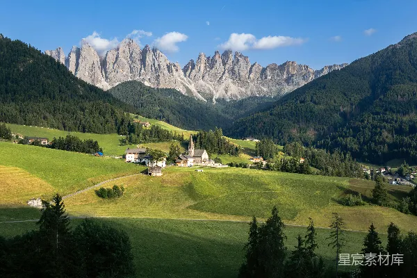 山峦中前景有一座教堂的美景