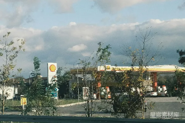 高清摄影 一条空荡荡的街道，背景中有一座加油站。