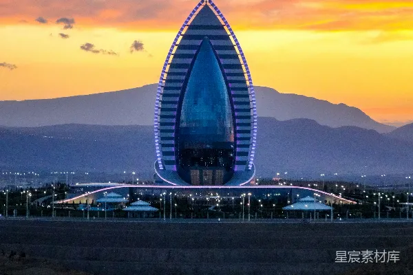 高清摄影 日落时分，现代建筑在山景的背景下被照亮。