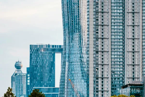 高清摄影 现代化摩天大楼在充满活力的城市中矗立在绿树之上。