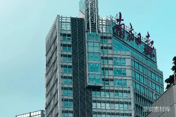 高清摄影 一座现代化的玻璃高楼矗立在浅蓝色的天空下。