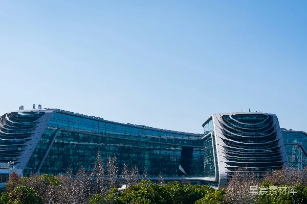 高清摄影 现代化的玻璃建筑，其曲面结构在晴朗的天空下显得格外引人注目。