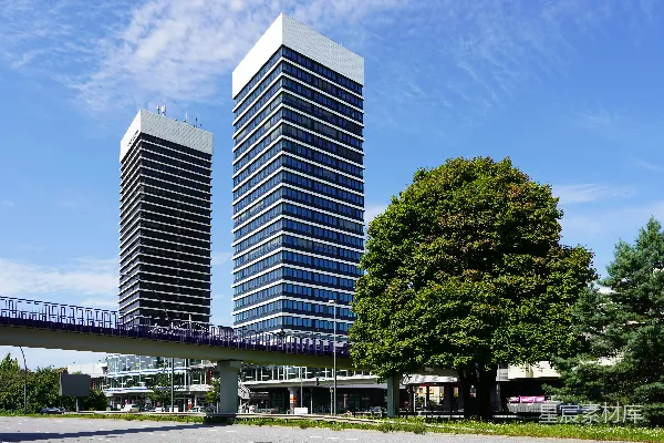 高清摄影 现代化的建筑、人行天桥和蓝天下的绿树。