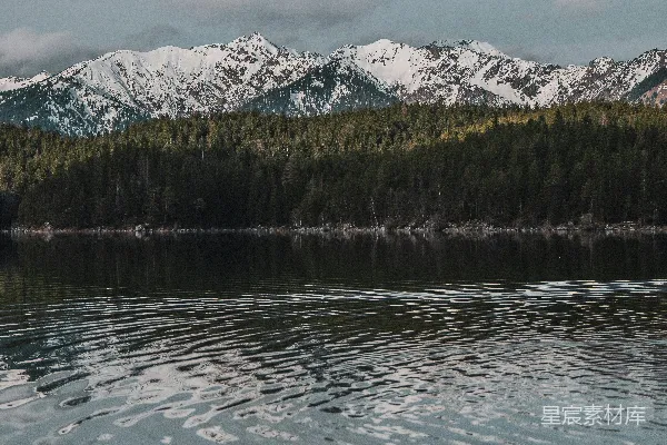 皑皑白雪映照在平静的湖水中。