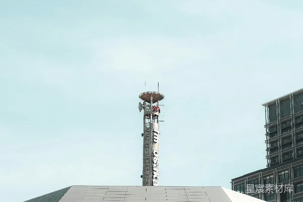 高清摄影 现代化的建筑在晴朗的天空下，旁边有一座通信塔。