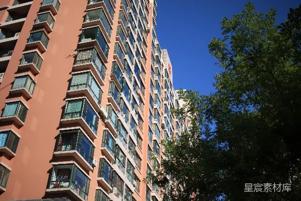 高清摄影 高层公寓楼，有许多窗户和树木。
