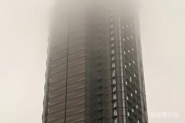 一栋高耸的建筑旁边有一座高大的钟表。