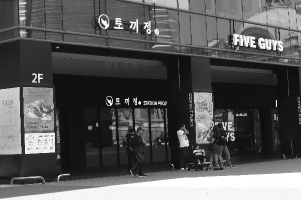 高清摄影 建筑外有“五个家伙”标志的人。