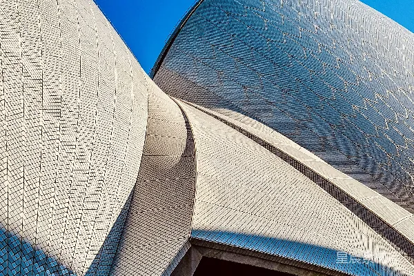 高清摄影 悉尼歌剧院的标志性白色贝壳建筑在蓝天背景下。