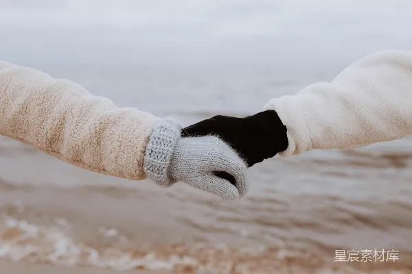 海滩上一对手牵手的人的手