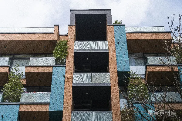 高清摄影 现代化建筑，带有蓝色和砖墙外立面，设有阳台和绿化。