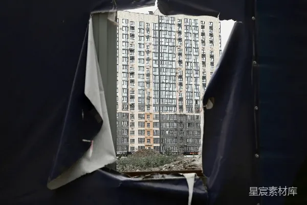高清摄影 透过破损的布料看到的高层公寓楼。