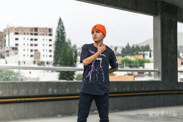 蓝白格衬衫和黑色裤子的男人站在灰色混凝土人行道上