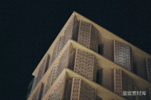 高清摄影 现代建筑的外墙，在夜晚呈现出带有图案的窗户。