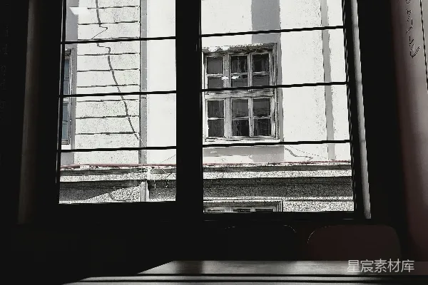 一张黑白照片，展示着一间黑暗房间里的窗户。