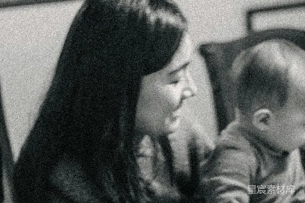 一位妇女坐在沙发上抱着一个婴儿。