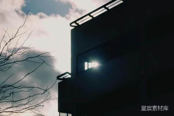 高清摄影 暗色建筑外立面，阳光透过窗户闪烁。
