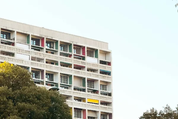 高清摄影 现代化的建筑，周围环绕着树木，阳台上装饰着五颜六色的栏杆。