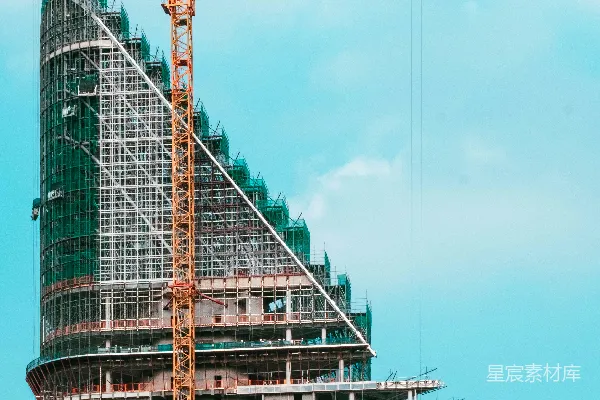 高清摄影 正在建设中的现代化建筑旁边有一台起重机。