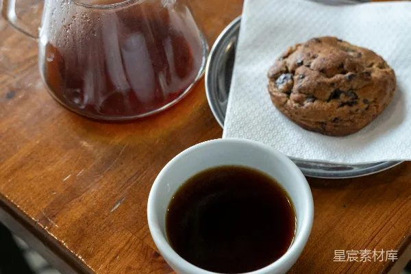 桌子上有杯茶和一块饼干。