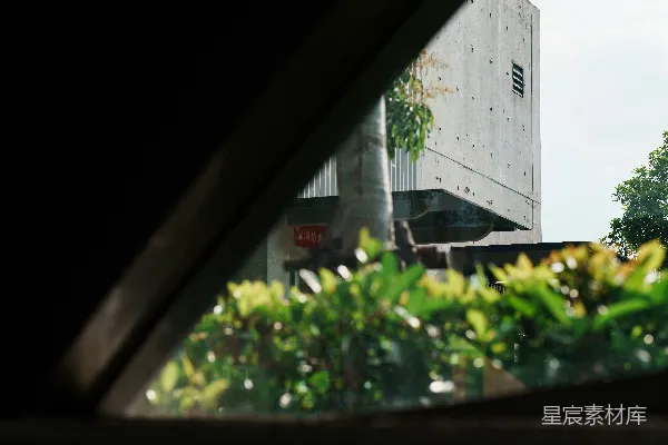 高清摄影 通过一个黑暗的三角形开口看到一座混凝土建筑物。
