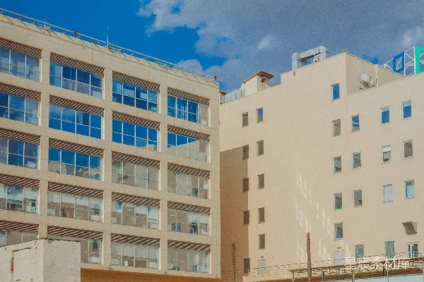 高清摄影 橙色汽车停在现代正在建设中的建筑物外。