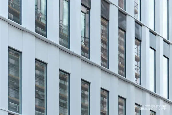 高清摄影 一座高楼，有很多窗户，紧挨着一条街道。