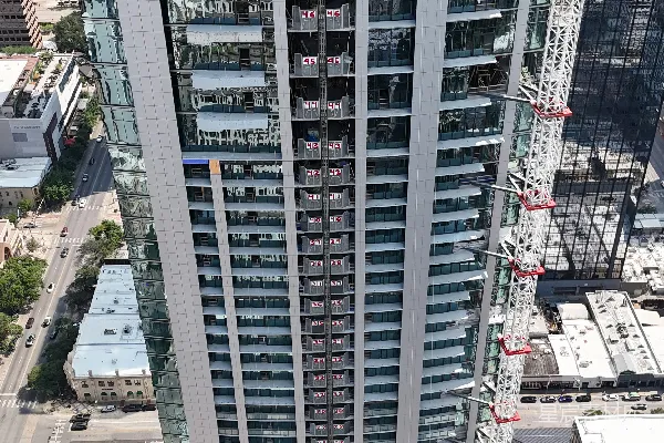 高清摄影 正在建设中的高大玻璃摩天大楼，旁边有起重机。