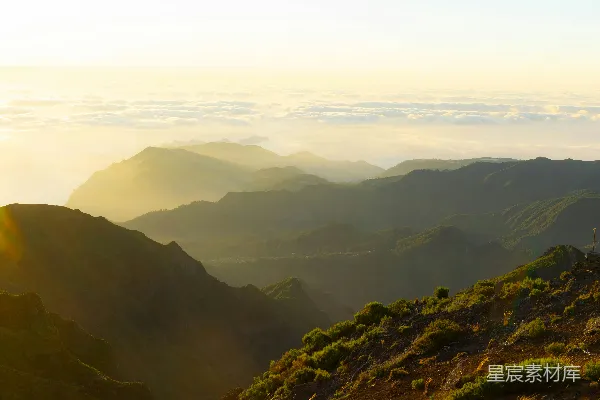 山峦之间阳光穿透云层的景象