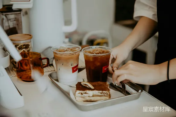 手持一个带有棕色和白色咖啡杯的白陶瓷盘的人