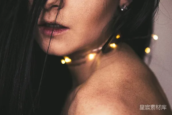 颈部挂着串灯的女人特写照片