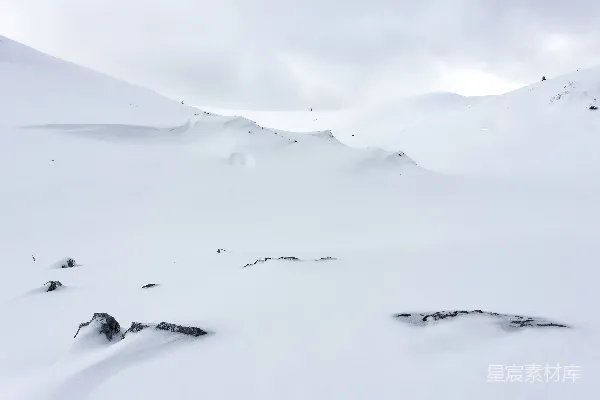 一个骑着雪板滑下覆有白雪的斜坡的人
