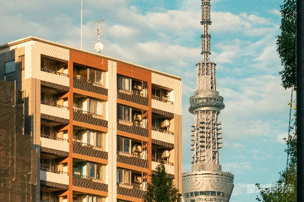 高清摄影 一座现代化的高楼耸立在多层住宅楼旁边。