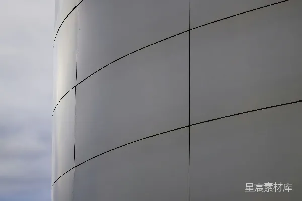 高清摄影 弯曲的现代建筑外墙与多云的天空对比
