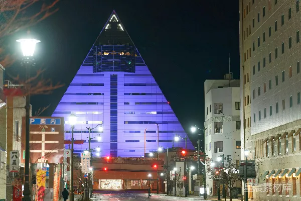 高清摄影 夜晚城市中一座被紫色灯光照亮的金字塔形建筑。