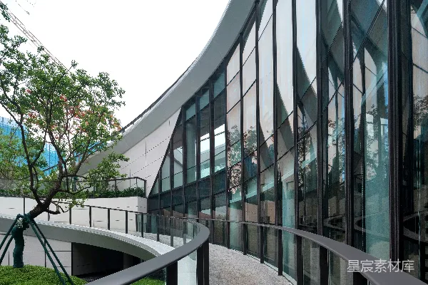 高清摄影 现代化建筑，带有弧形走廊和玻璃幕墙。