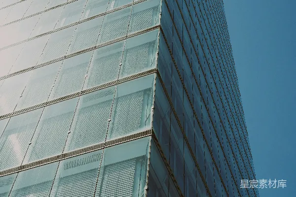 高清摄影 一座现代化的玻璃摩天大楼，背景是清澈的蓝天。