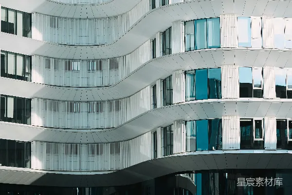 高清摄影 一座现代的白色波浪形建筑，一个人从旁边走过。