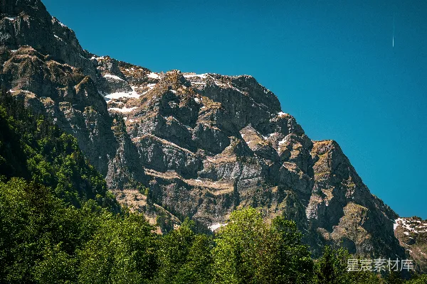 雪冠山峰，绿树蓝天。