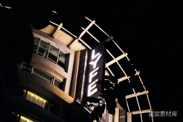 高清摄影 现代化的建筑在夜间被照亮的标志牌照耀着。