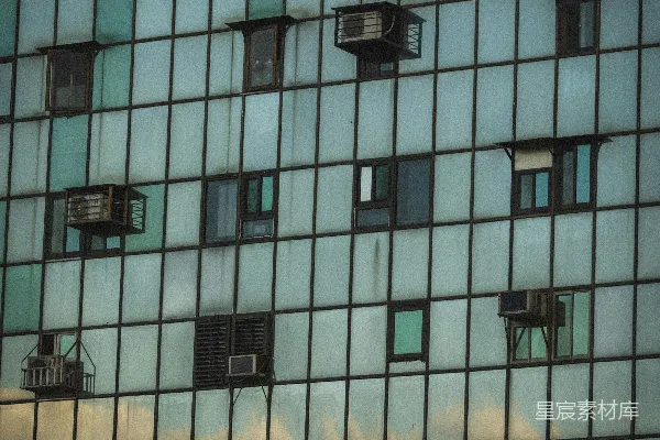 高清摄影 现代化建筑的外立面，有许多窗户和空调设备。