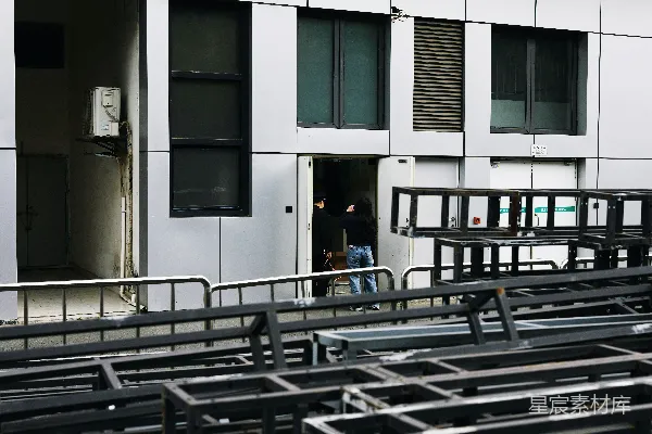 高清摄影 一个人进入了一座建筑，建筑外面有金属结构。