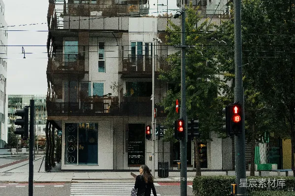 高清摄影 在现代高楼前过马路的女人。