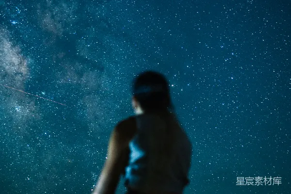一个人在星光璀璨的夜空前站立