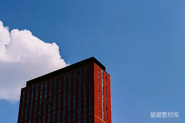 高清摄影 一座高大的红色建筑坐落在多云的蓝天之下。