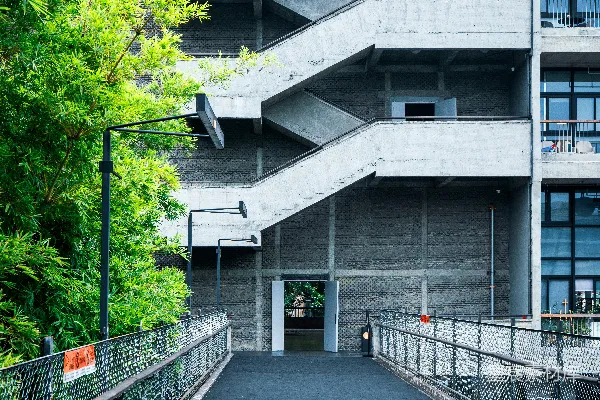高清摄影 混凝土建筑，带有室外楼梯和绿色树木。