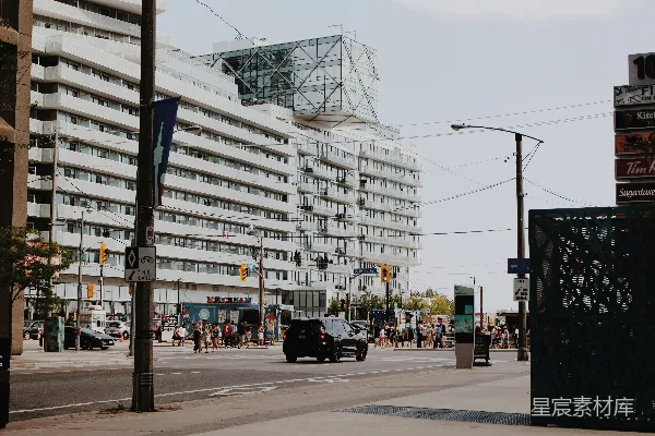 高清摄影 城市街道场景，有建筑物、车辆和行人。