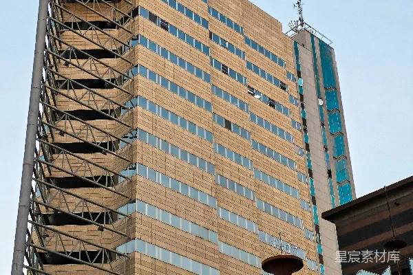 高清摄影 高耸的现代化建筑，背景是蓝天，建筑外立面有金属结构。